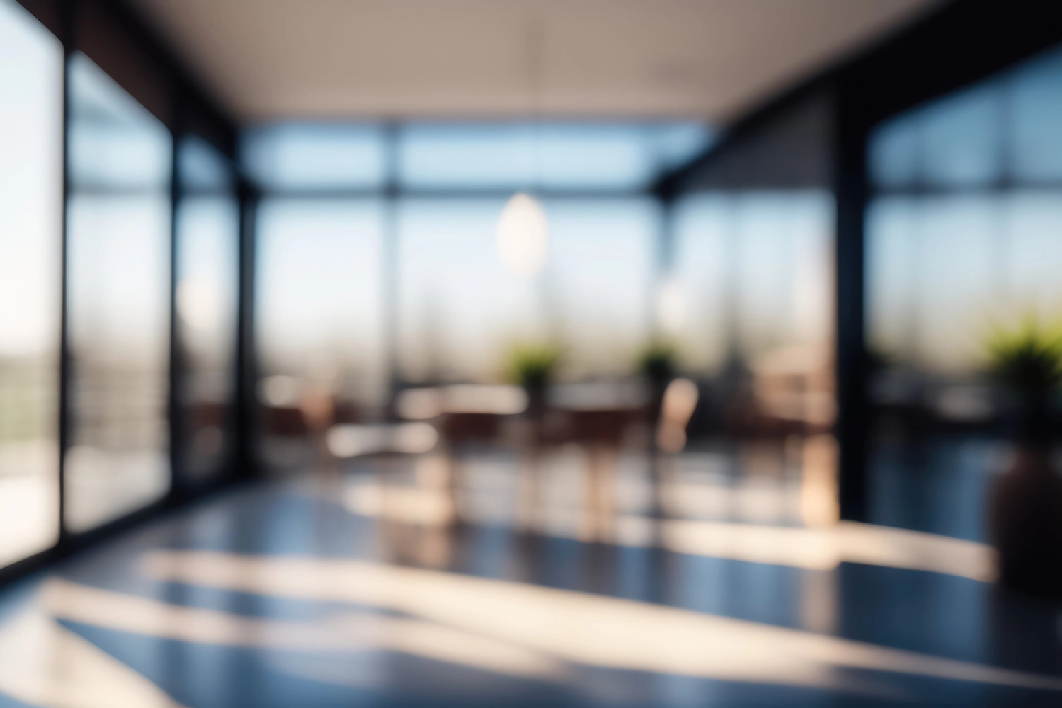 OLAG Gebäudeservice - Reinigungsfirma - Wunderschöner, verschwommener Hintergrund zeigt ein helles, modernes Bürointerieur mit Panoramafenstern und schöner Beleuchtung.